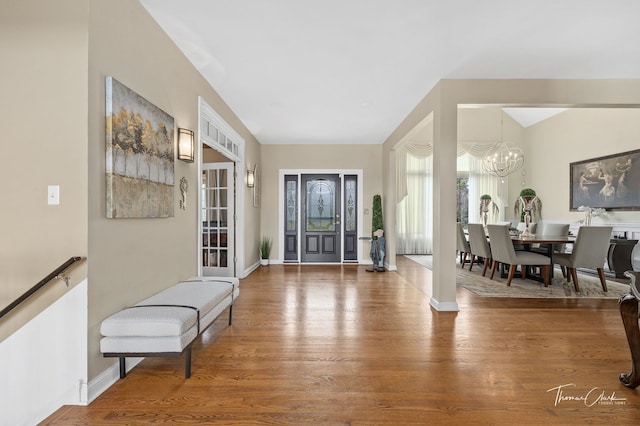 entrance foyer with hardwood / wood-style floors and a notable chandelier