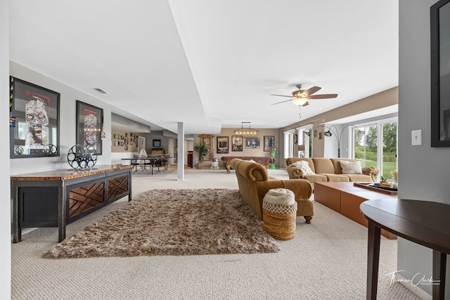 carpeted living room with ceiling fan with notable chandelier