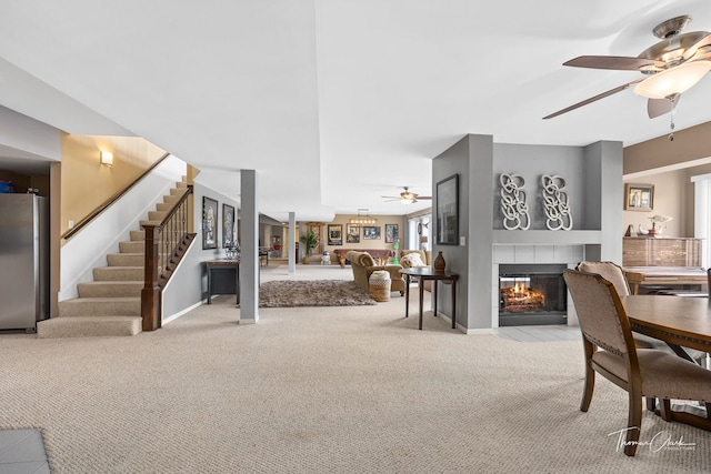 living room with ceiling fan, light colored carpet, and a fireplace