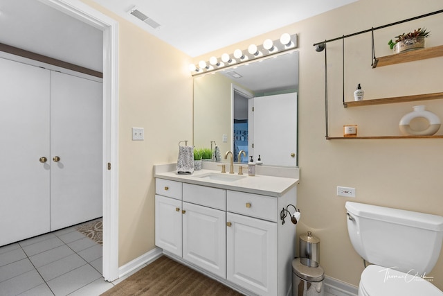 bathroom featuring tile patterned flooring, vanity, and toilet