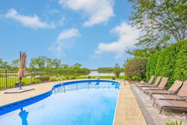 view of pool featuring a water view and a patio