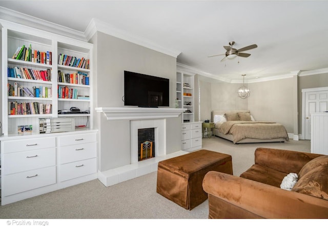 carpeted bedroom featuring crown molding, a fireplace, and ceiling fan with notable chandelier