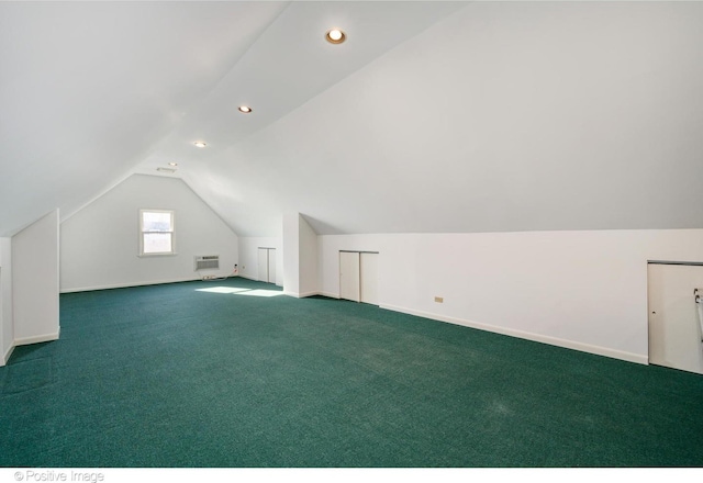 additional living space featuring vaulted ceiling, carpet flooring, and a wall mounted AC