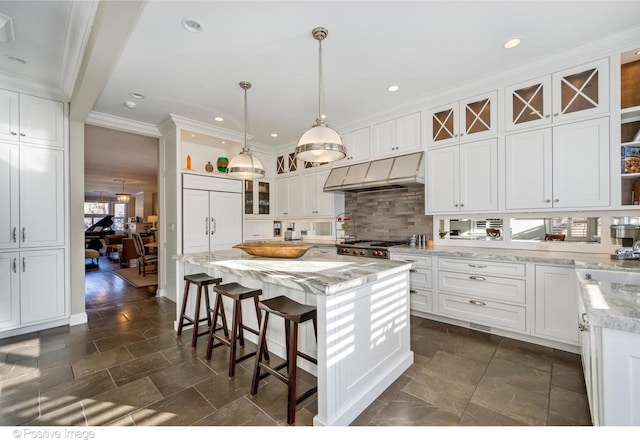 kitchen featuring white cabinetry, light stone counters, hanging light fixtures, paneled built in refrigerator, and a kitchen island