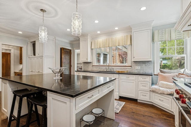 621 E Prospect Ave, Lake Bluff, IL 60044 - kitchen featuring a sink, ornamental molding, white cabinetry, tasteful backsplash, and a chandelier