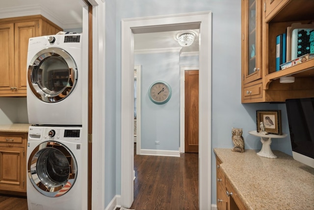 621 E Prospect Ave, Lake Bluff, IL 60044 - washroom featuring stacked washer / dryer, cabinet space, crown molding, dark wood-type flooring, and baseboards