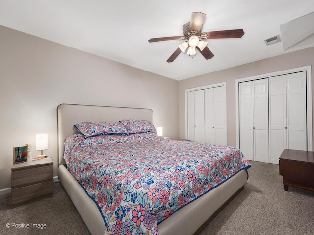 carpeted bedroom featuring two closets and ceiling fan