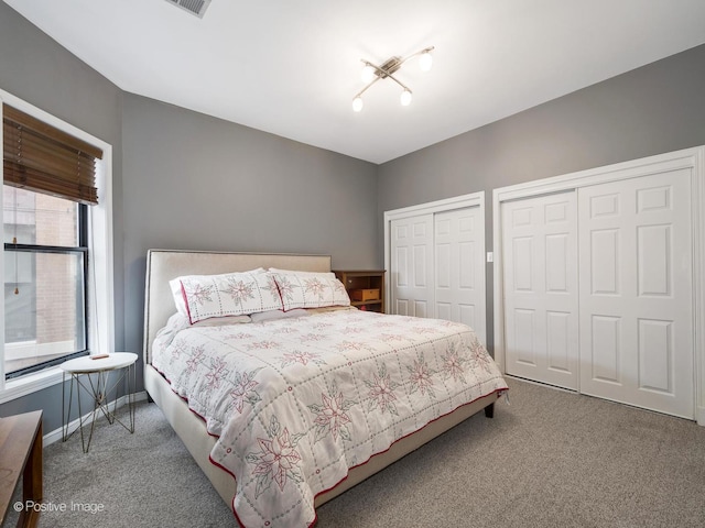 carpeted bedroom featuring two closets