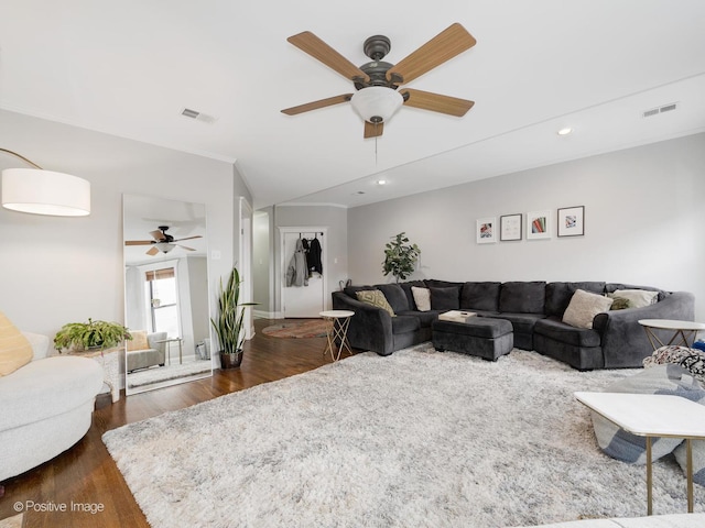 living room with crown molding, dark hardwood / wood-style floors, and ceiling fan