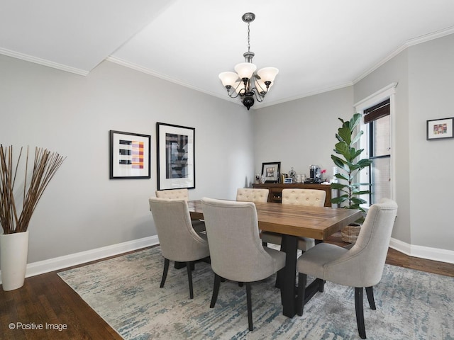 dining area featuring an inviting chandelier, ornamental molding, and dark hardwood / wood-style floors