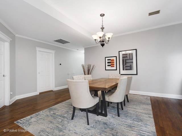 dining room with ornamental molding, a chandelier, and dark hardwood / wood-style flooring