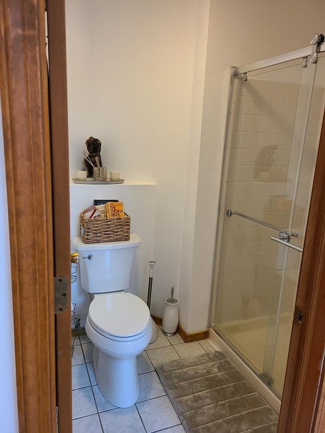 bathroom with a shower with shower door, tile patterned floors, and toilet