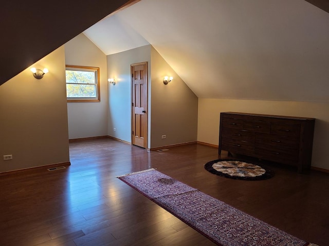 bonus room with lofted ceiling and dark wood-type flooring