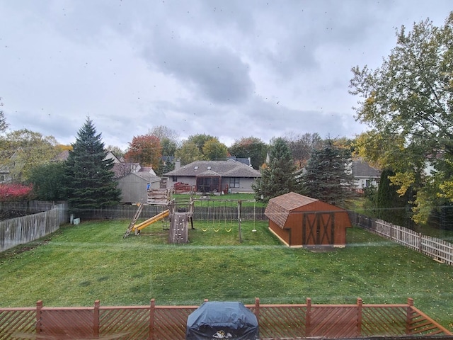 view of yard featuring a storage unit and a playground