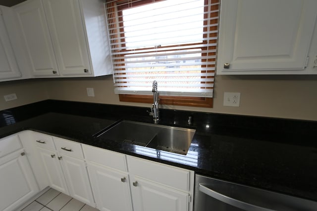 kitchen featuring white cabinetry, sink, stainless steel dishwasher, and light tile patterned floors