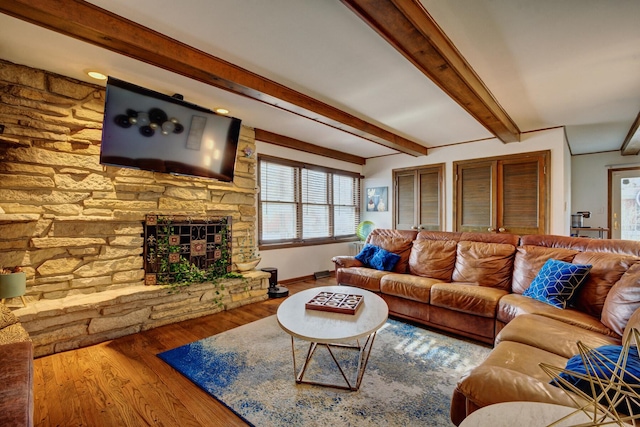 living room with beamed ceiling, hardwood / wood-style floors, and a fireplace