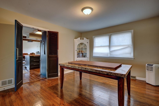 home office with dark hardwood / wood-style flooring