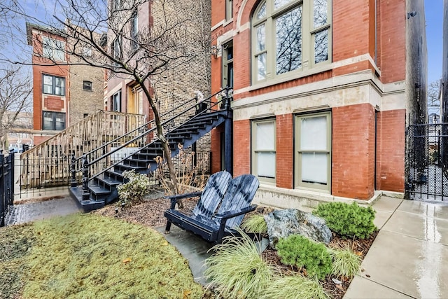 view of building exterior with stairway and fence