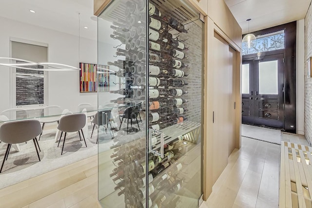 wine cellar featuring recessed lighting, wood finished floors, and french doors