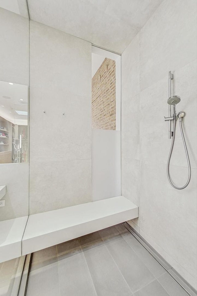 bathroom featuring tile patterned flooring and tiled shower