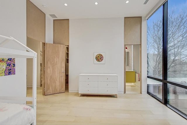 unfurnished bedroom with recessed lighting, light wood-style floors, and expansive windows