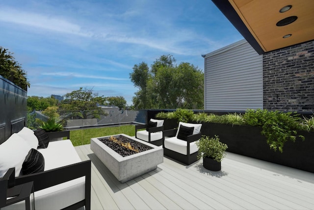 wooden terrace featuring an outdoor living space with a fire pit