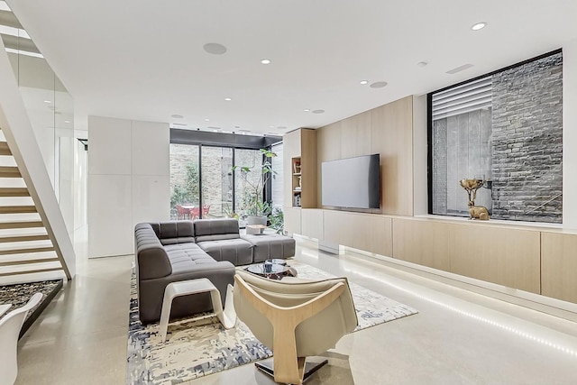 living area with recessed lighting, concrete flooring, and expansive windows