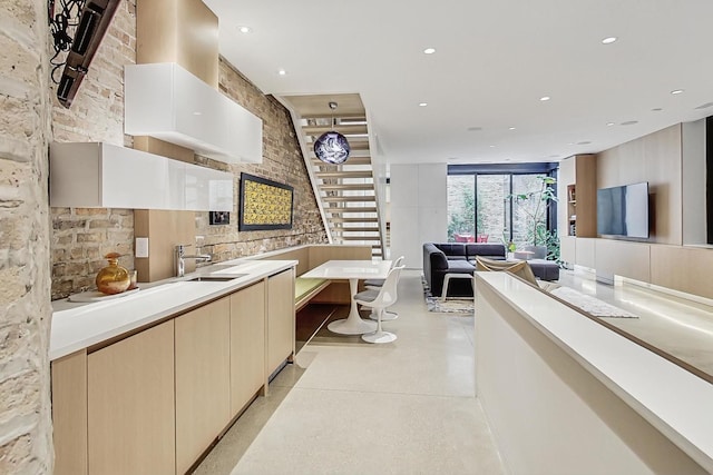 kitchen with open floor plan, recessed lighting, light countertops, and a sink