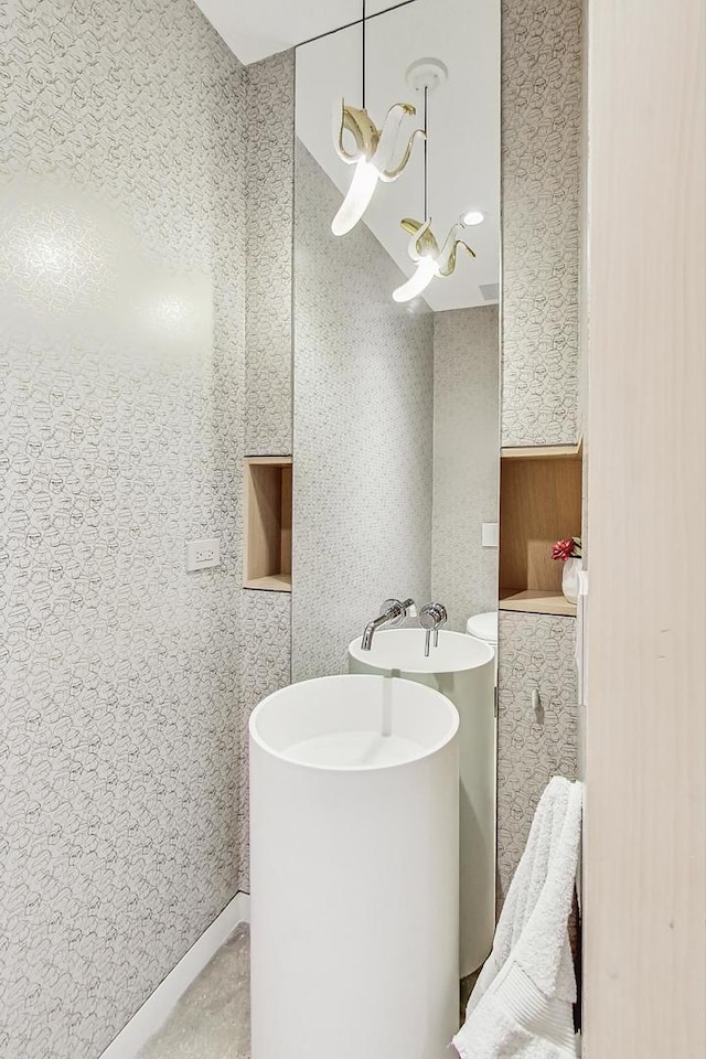 bathroom featuring a sink and wallpapered walls