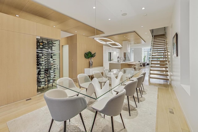 dining room with light wood finished floors, visible vents, recessed lighting, and stairs