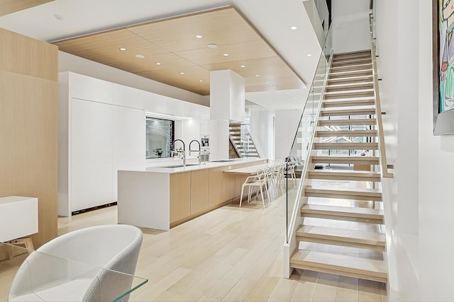 stairs with recessed lighting and wood finished floors