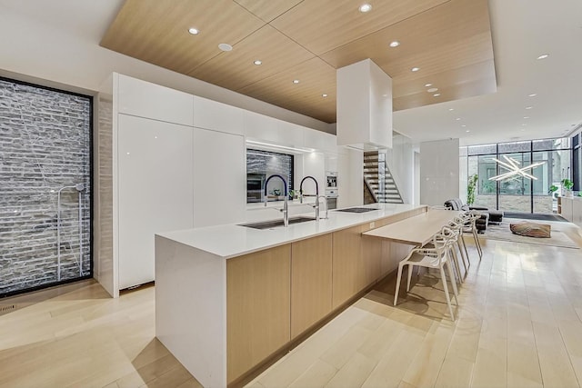 kitchen featuring wood ceiling, floor to ceiling windows, modern cabinets, and a sink