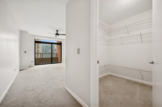 walk in closet featuring ceiling fan and light carpet