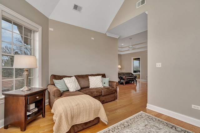 living room with ornamental molding, lofted ceiling, ceiling fan, and light hardwood / wood-style flooring