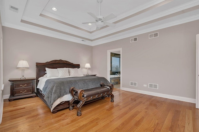 bedroom with crown molding, a raised ceiling, ceiling fan, and light wood-type flooring