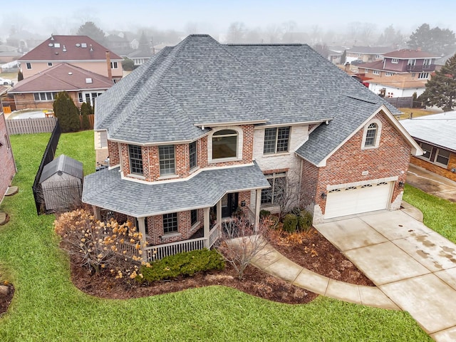 front of property featuring a garage, a front lawn, and covered porch