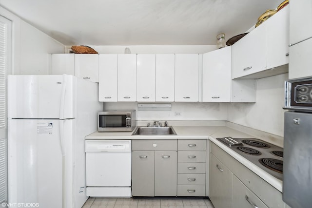 kitchen featuring sink, white cabinets, and white appliances