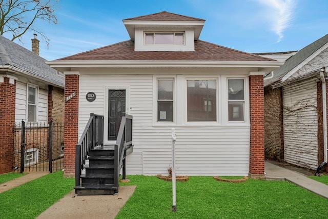 bungalow-style house featuring a front lawn