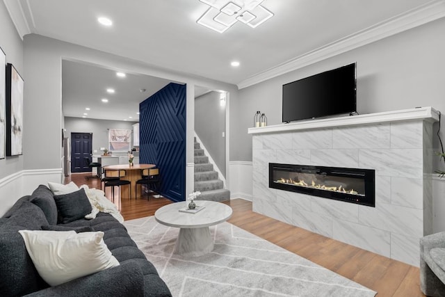 living room featuring crown molding, hardwood / wood-style floors, and a fireplace