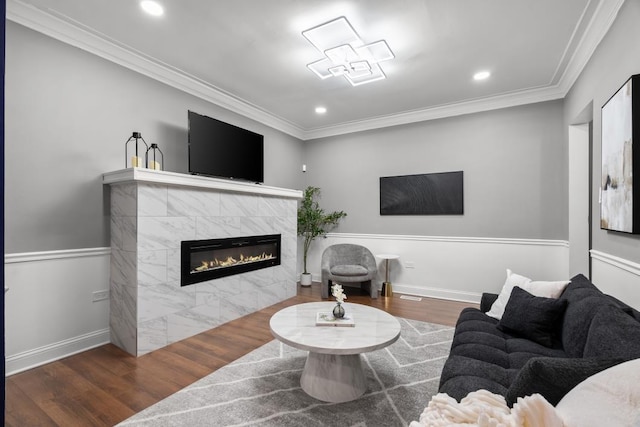 living room with crown molding, dark hardwood / wood-style flooring, and a tiled fireplace