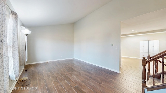 unfurnished room with stairway, wood finished floors, and baseboards