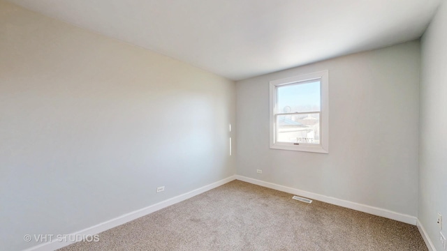 carpeted spare room with baseboards and visible vents