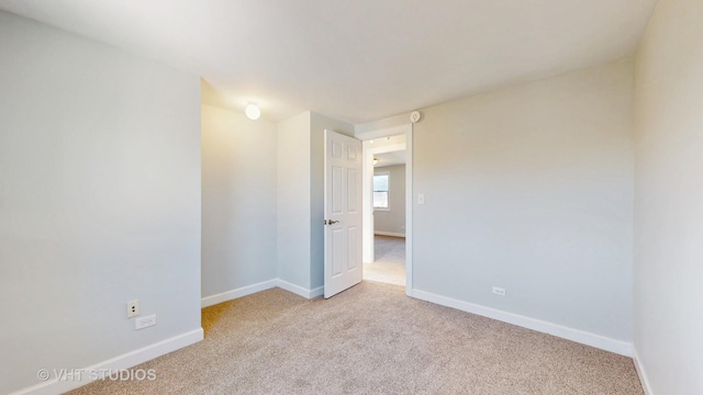 unfurnished room with carpet floors and baseboards