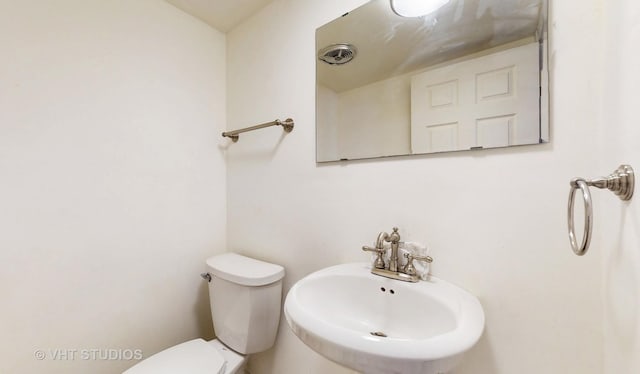 bathroom featuring visible vents, a sink, and toilet