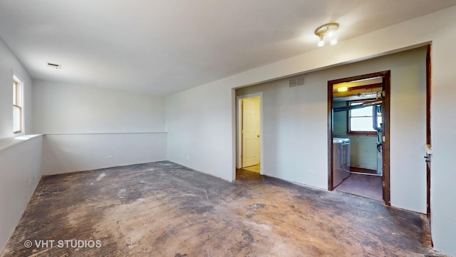 empty room featuring visible vents, washing machine and clothes dryer, and unfinished concrete floors