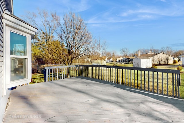 wooden deck with a residential view, fence, and a yard