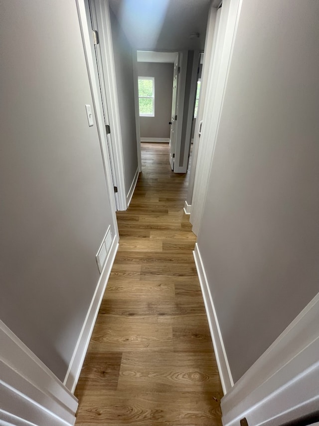 corridor with light hardwood / wood-style floors