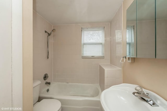 full bathroom with toilet, tiled shower / bath combo, and sink