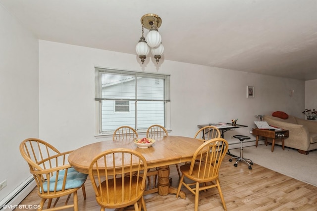 dining area featuring a baseboard radiator and light wood-type flooring