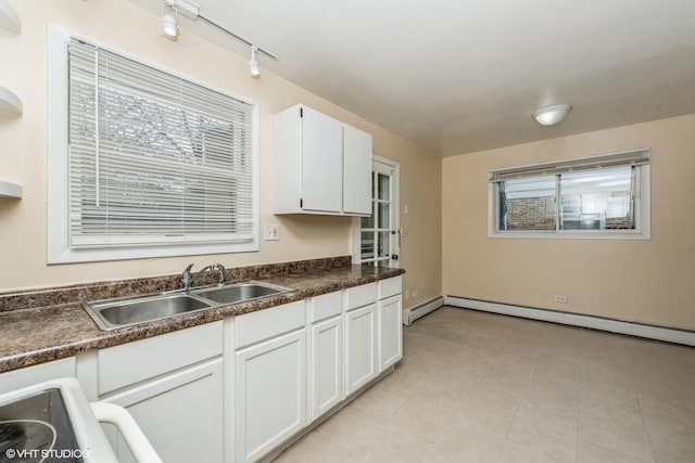 kitchen featuring white cabinetry, a baseboard radiator, and sink